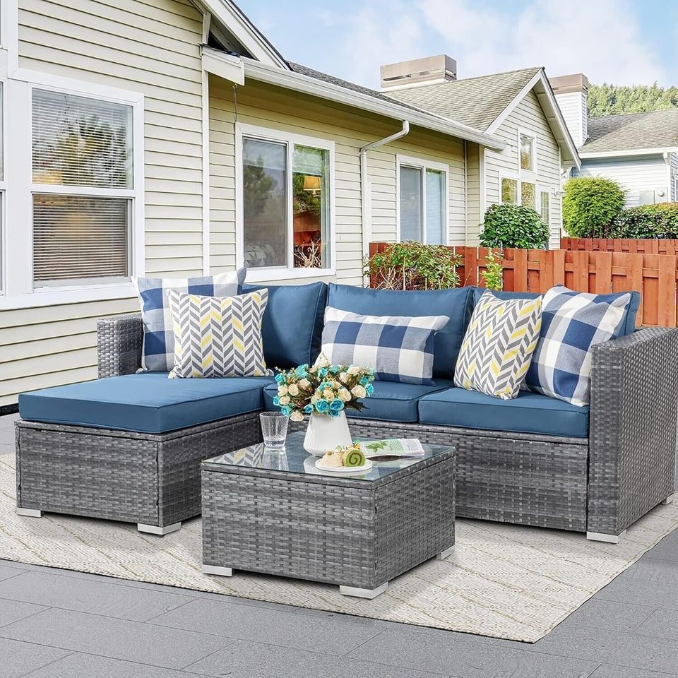 Outdoor Patio Sofa Set with Table | Grey/Blue from AHF Depot - Grey sectional couch with dark blue cushions and a small glass top table, complemented by breakfast essentials and a few books, set against a sunny outdoor patio backdrop.