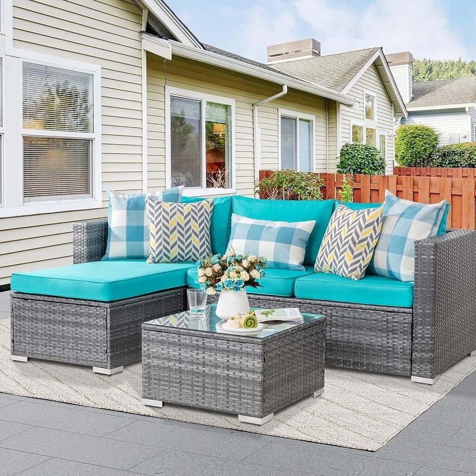 Outdoor Patio Sofa Set with Table | Grey/Teal from AHF Depot - Grey sectional couch with teal blue cushions and a small glass top table, complemented by breakfast essentials and a few books, set against a sunny outdoor patio backdrop.