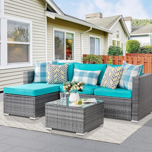 Outdoor Patio Sofa Set with Table | Grey/Teal from AHF Depot - Grey sectional couch with teal blue cushions and a small glass top table, complemented by breakfast essentials and a few books, set against a sunny outdoor patio backdrop.