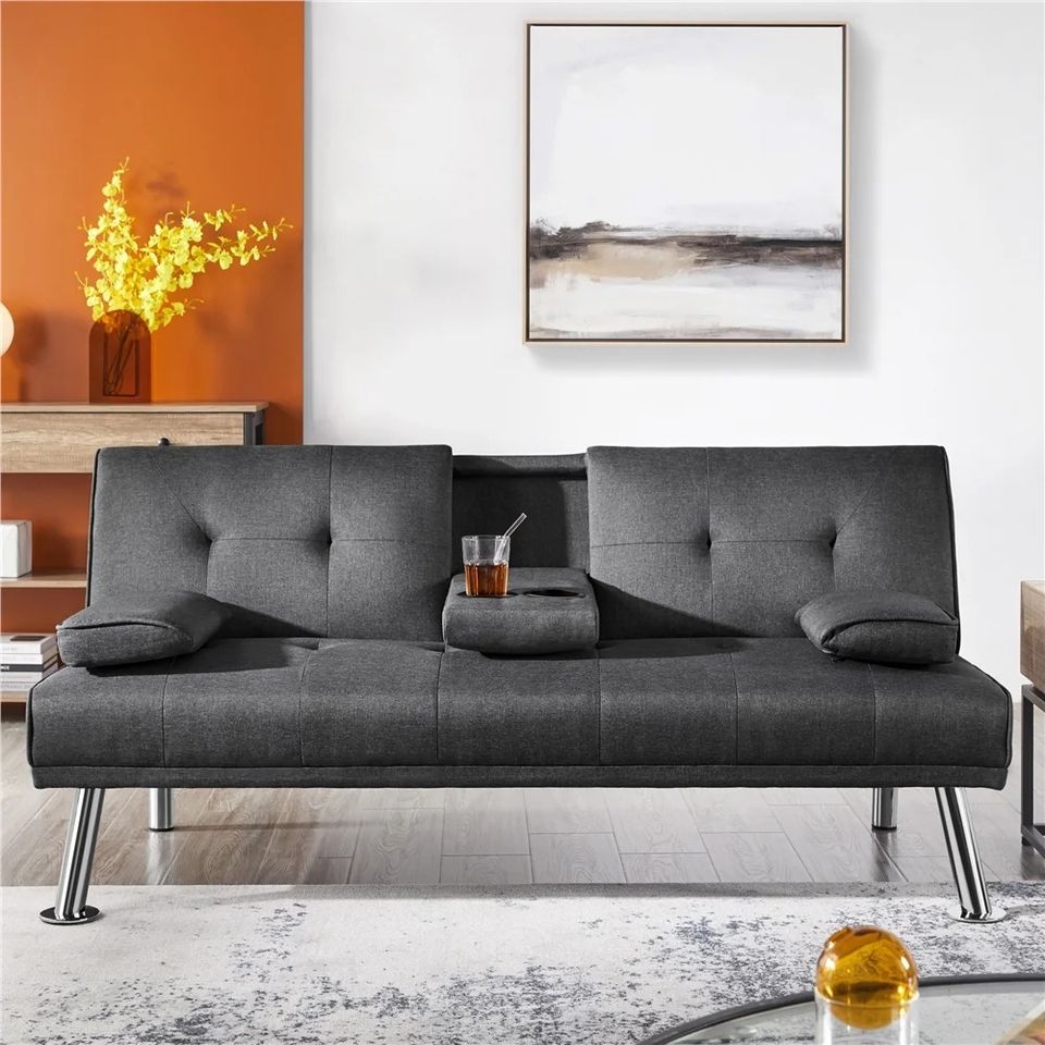 Couch Bed Futon Sleeper Sofa for Living Room | Grey from AHF Depot - Grey fabric futon with center cupholders displayed against split color background in a modern living room scene.