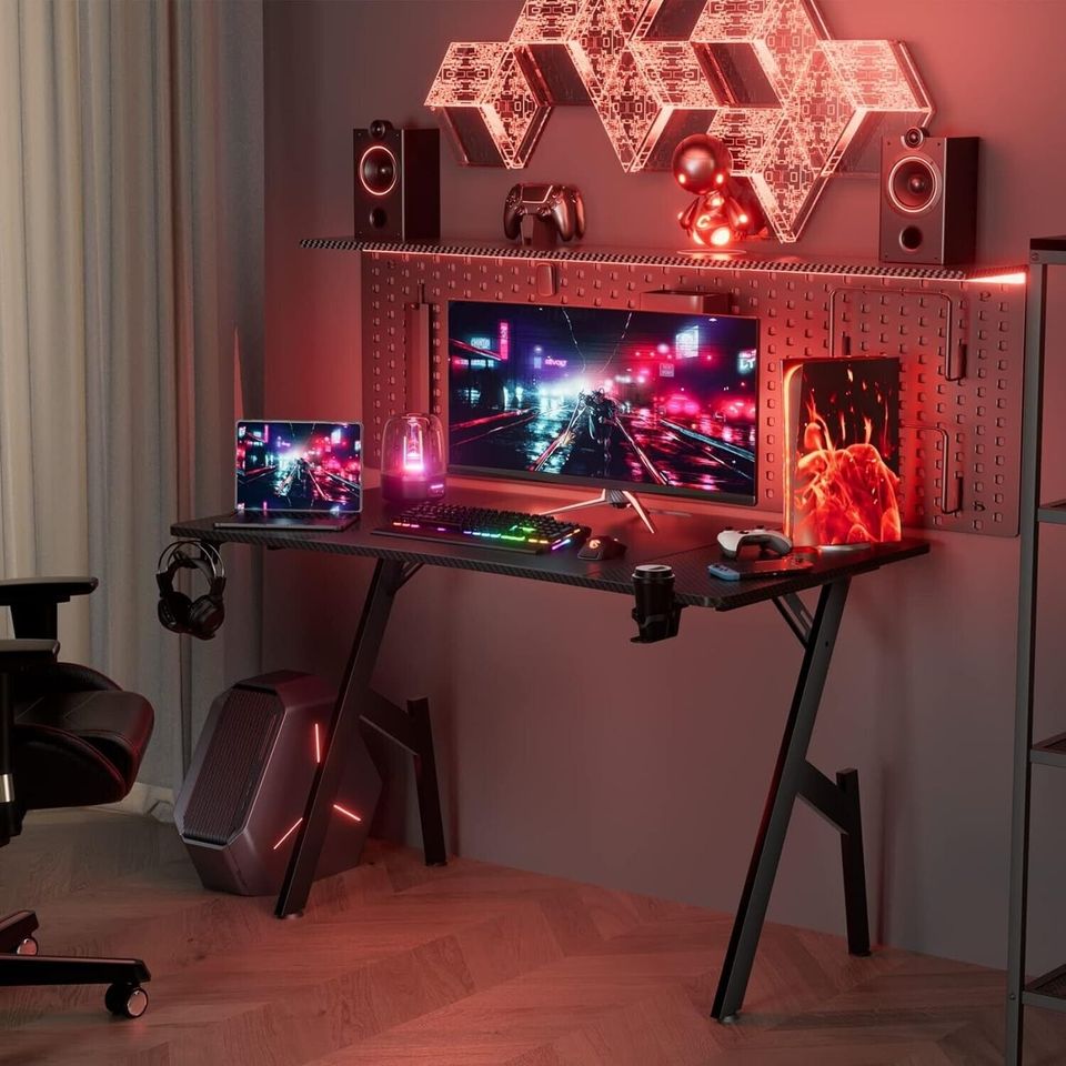 Desk for Gaming Computer PC in Bedroom - 47" | Black from AHF Depot - Black Gaming Desk featuring an advanced gaming PC setup in a modern bedroom setting with a red hue.