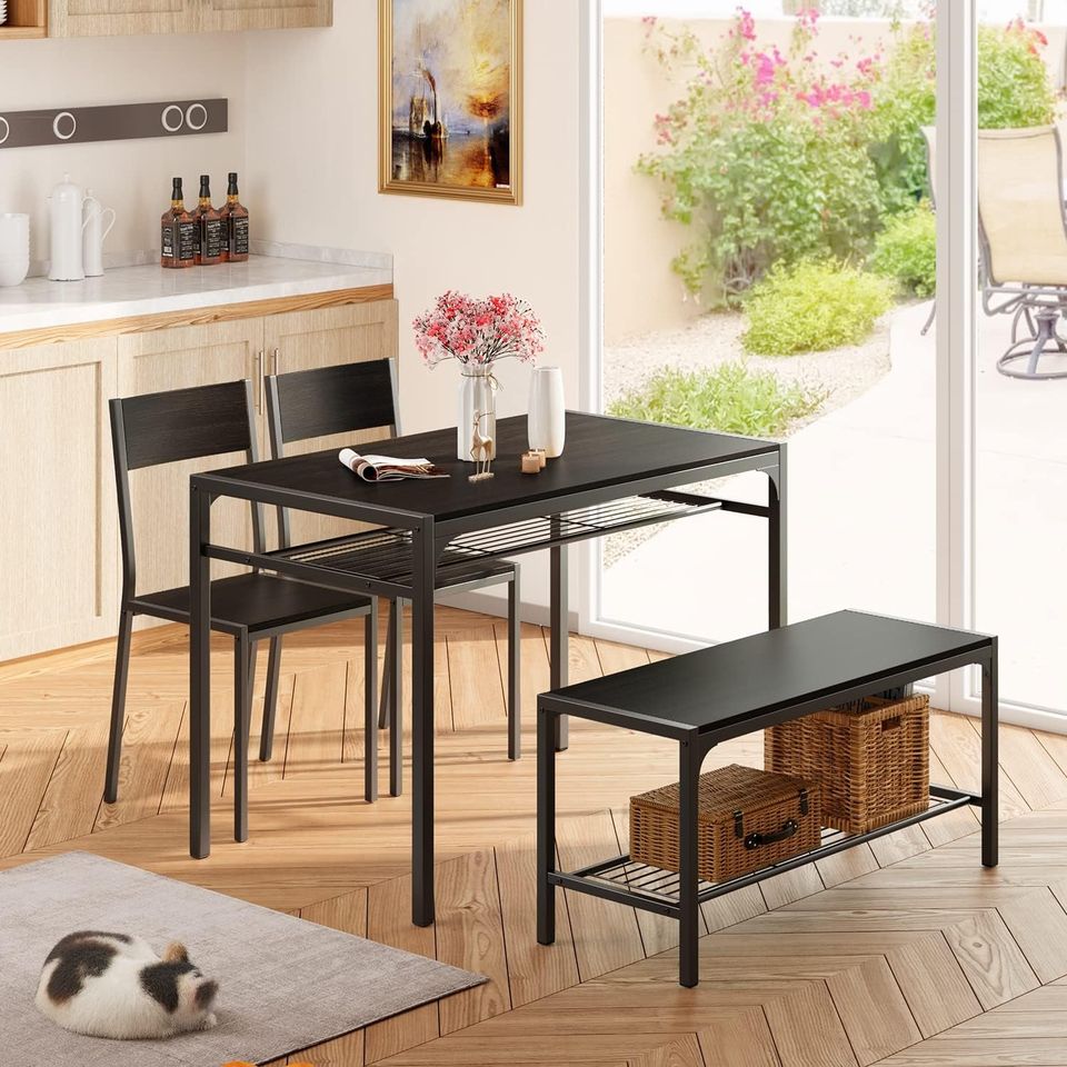 Dining Set Includes Table, Chairs, and Bench for Kitchen | Black from AHF Depot - Modern black dining table with built-in shelving, accompanied by two chairs and a bench. Indoor dining room scene with flowers on the table and a cat sleeping by the table in front of a glass sliding door.