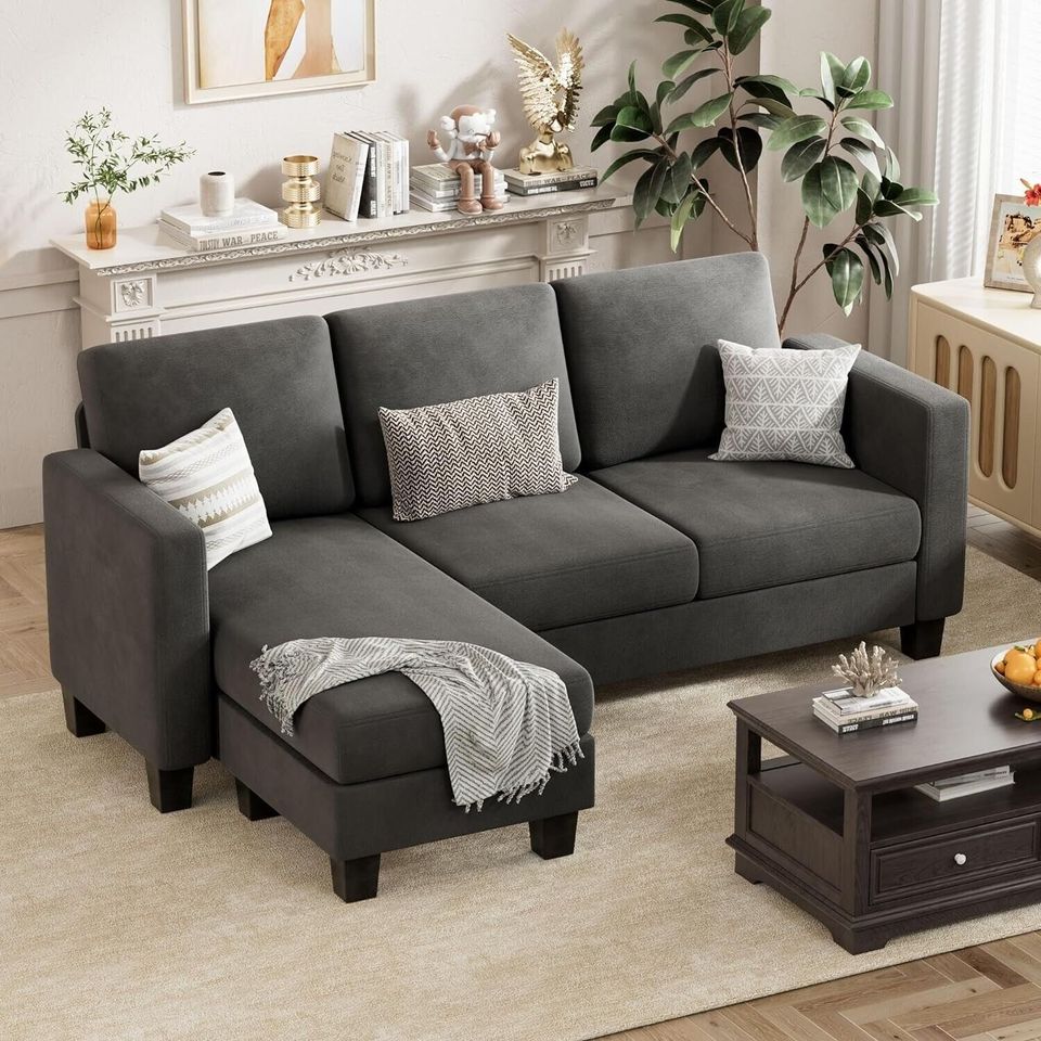 Couch Sectional Sofa with Ottoman for Living Room | Dark Grey from AHF Depot - Dark Grey sectional sofa with a right-side chaise, complementing a light tone modern living room scene placed in front of a fireplace.