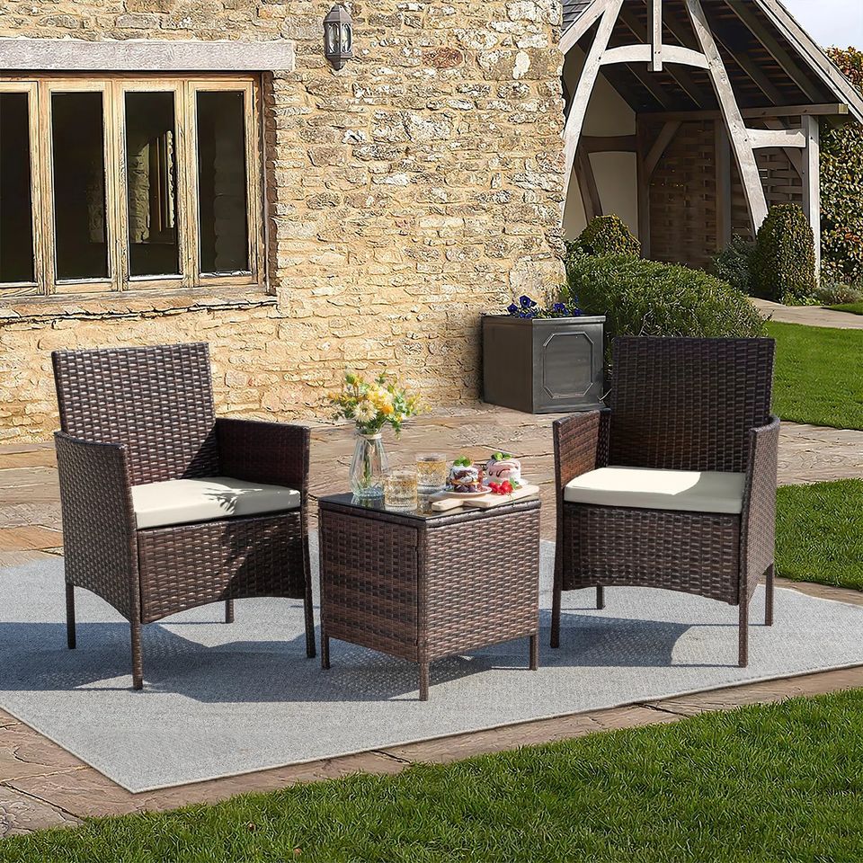 Outdoor Patio Chairs and Table Set | Brown/Tan from AHF Depot - Modern brown rattan frame patio conversation set with tan cushions and small glass top table, set against a sunny outdoor patio setting.