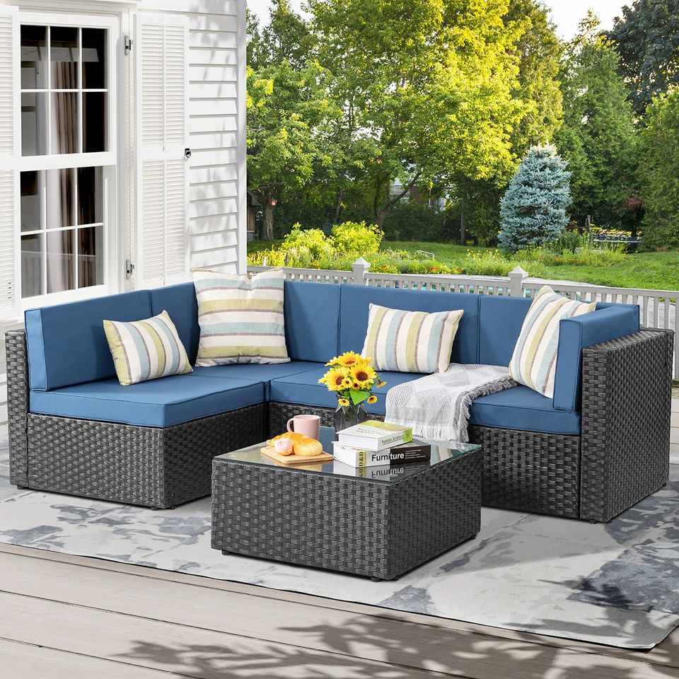 Outdoor Patio Sofa Set with Table | Black/Blue from AHF Depot - Black sectional couch with dark blue cushions and a small glass top table, complemented by breakfast essentials and a few books, set against a sunny outdoor patio backdrop.