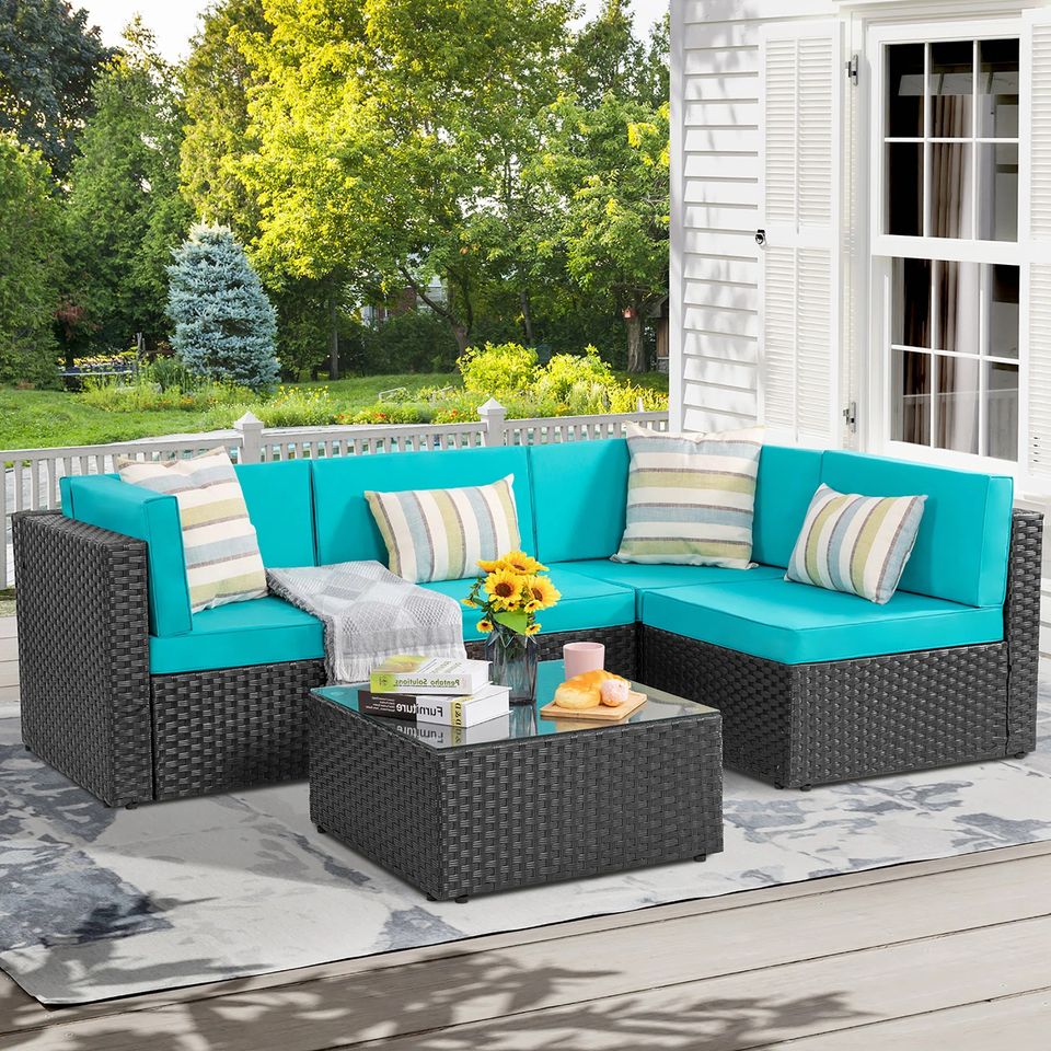 Outdoor Patio Sofa Set with Table | Black/Teal from AHF Depot - Black sectional couch with teal blue cushions and a small glass top table, complemented by breakfast essentials and a few books, set against a sunny outdoor patio backdrop.