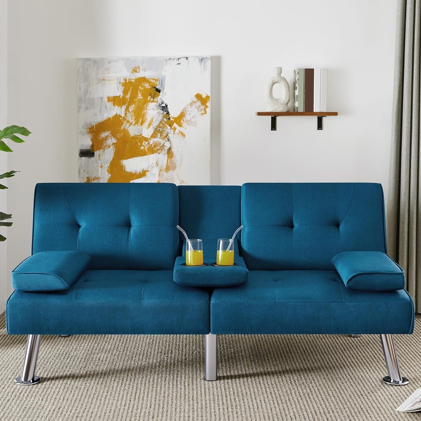 Couch Bed Futon Sleeper Sofa for Living Room | Blue from AHF Depot - Blue fabric futon with center cupholders displayed against a modern living room scene, offering a view of an abstract painting.