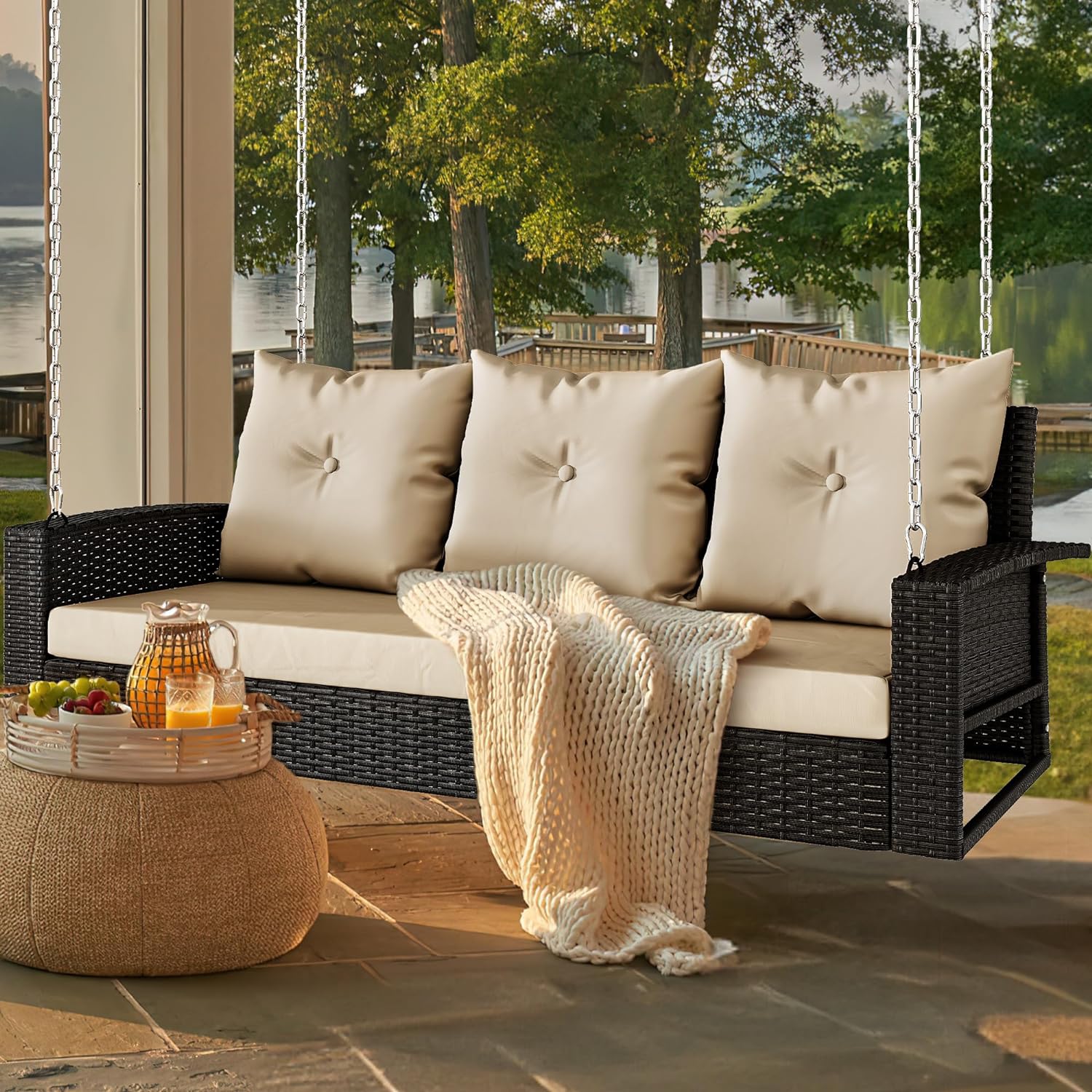 Outdoor Padded Porch Swing Hanging 3 Seater Chair | Black/Tan from AHF Depot - Modern black rattan frame hanging porch swing with tan cushions set against a sunny outdoor patio setting.