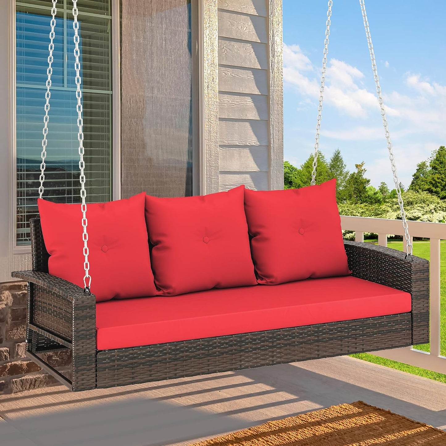 Outdoor Padded Porch Swing Hanging 3 Seater Chair | Brown/Red from AHF Depot - Modern brown rattan frame hanging porch swing with red cushions set against a sunny outdoor porch setting.