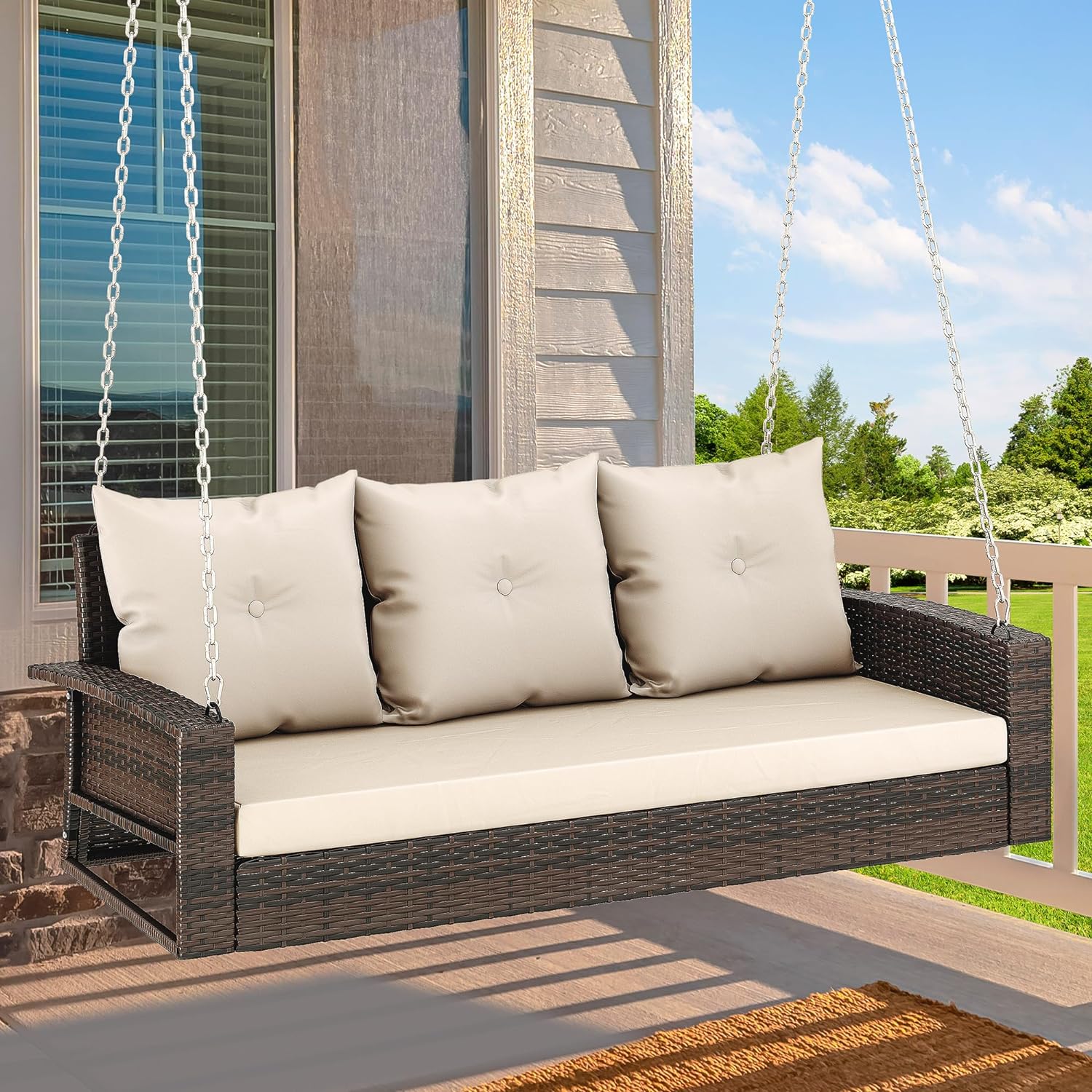 Outdoor Padded Porch Swing Hanging 3 Seater Chair | Brown/Tan from AHF Depot - Modern brown rattan frame hanging porch swing with tan cushions set against a sunny outdoor porch setting.