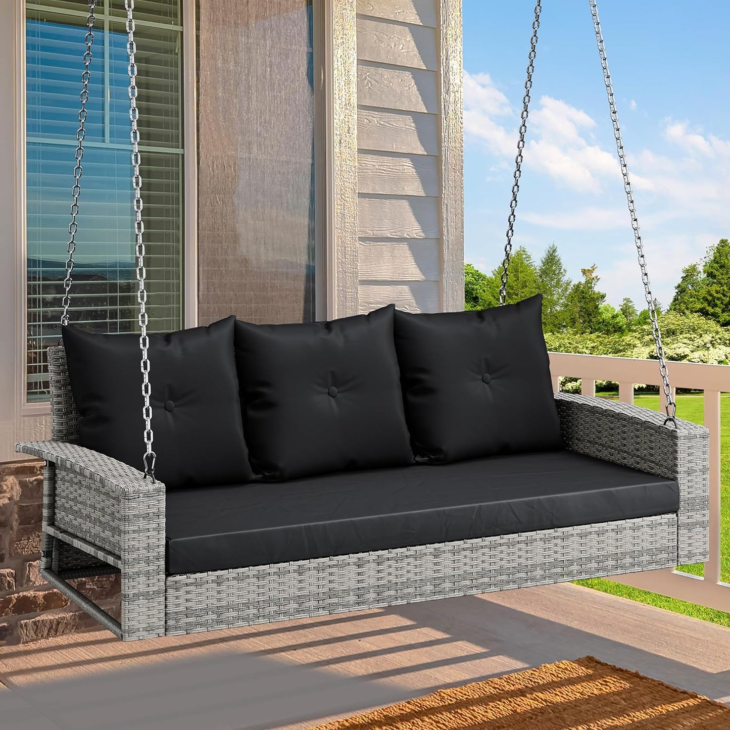 Outdoor Padded Porch Swing Hanging 3 Seater Chair | Grey/Black from AHF Depot - Modern grey rattan frame hanging porch swing with black cushions set against a sunny outdoor porch setting.