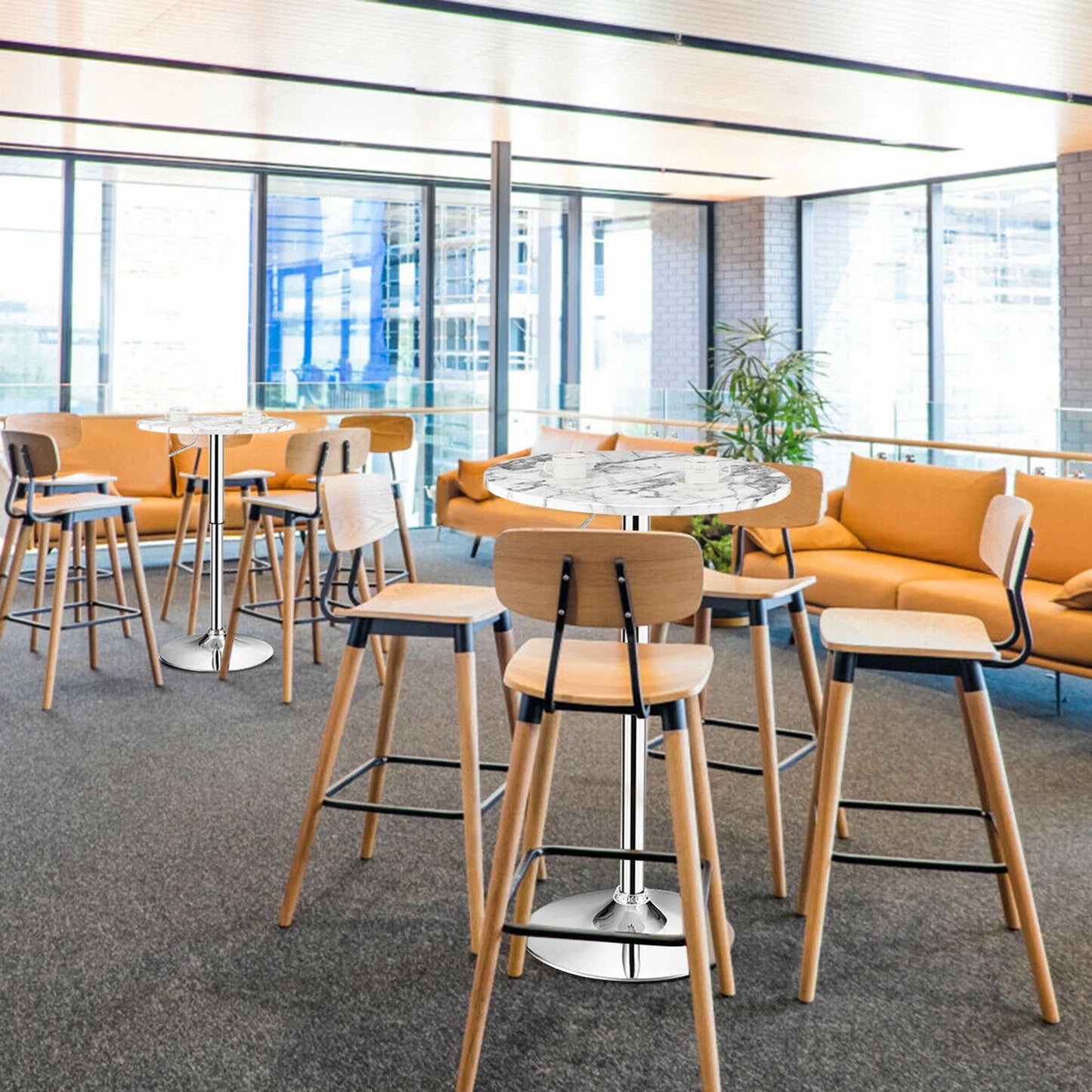 Bar Table Round with Adjustable Height and Swivel | White from AHF Depot - Two modern white marble top bar tables with a sleek silver frame, each surrounded by four wooden chairs, in a vibrant college lounge scene.